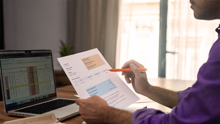 Homem segurando e analisando conta de luz