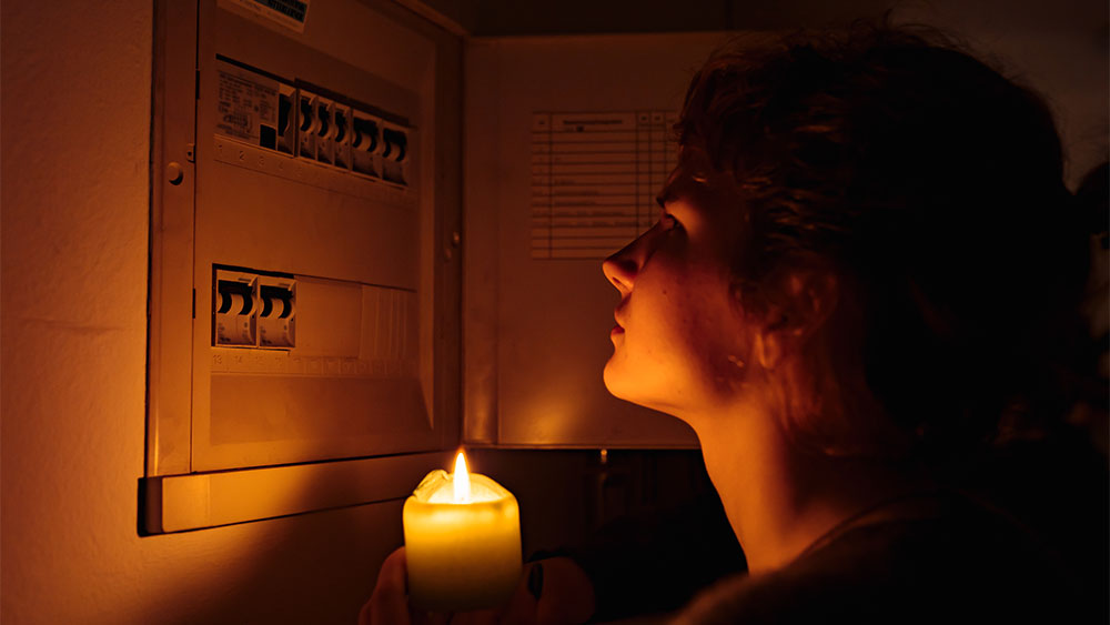 Mulher verificando quadro de luz durante queda de energia
